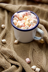 Image showing camp mug full of marshmallow on knitted blanket