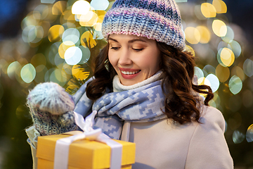Image showing happy woman with christmas gift over lights