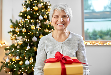 Image showing smiling senior woman with christmas gift at home