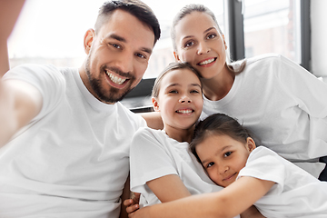 Image showing happy family taking selfie in bed at home