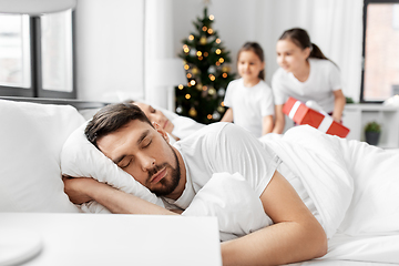 Image showing happy children wake their parents on christmas