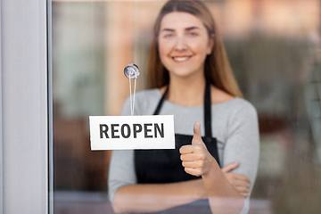 Image showing woman with reopen banner on door showing thumbs up