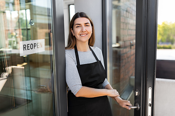 Image showing happy woman with reopen banner on door glass