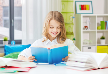 Image showing happy smiling student girl reading book at home