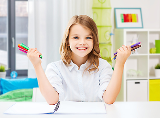 Image showing smiling girl with colorful felt-tip pens at home