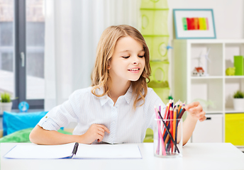 Image showing happy girl drawing with pencils at home