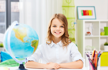 Image showing happy smiling student girl with globe at home