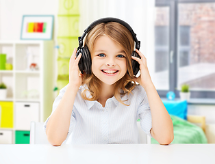 Image showing happy smiling girl with headphones at home