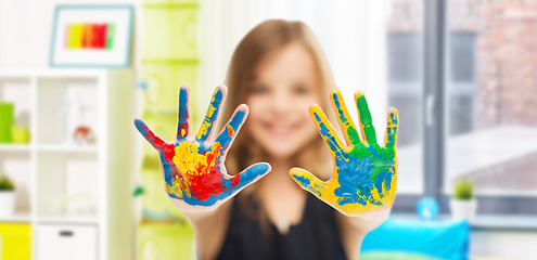 Image showing smiling girl showing painted hands at home