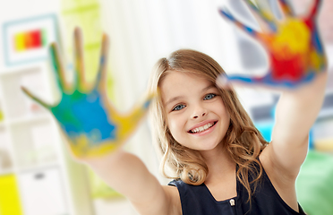 Image showing smiling girl showing painted hands at home