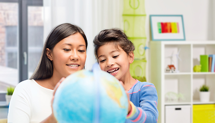 Image showing mother and daughter with globe at home