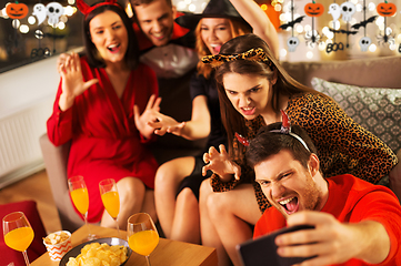 Image showing happy friends in halloween costumes taking selfie