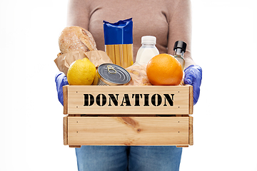 Image showing woman in gloves with food donation in wooden box