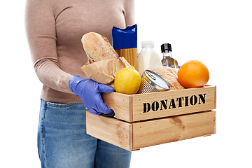 Image showing woman in gloves with food donation in wooden box