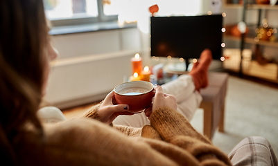 Image showing woman watches tv and drinks cocoa on halloween