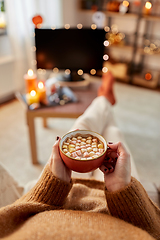 Image showing woman watches tv and drinks cocoa on halloween