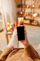 Image showing woman using smartphone at home on halloween