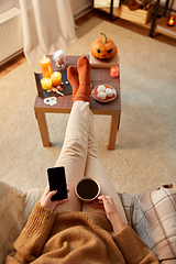Image showing woman using smartphone at home on halloween