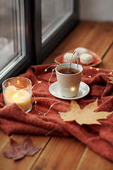 Image showing cup of tea and candle on window sill in autumn