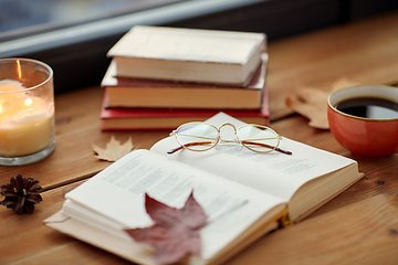 Image showing book, coffee and candle on window sill in autumn