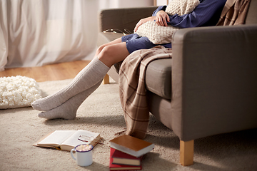 Image showing woman in socks with pillow and books at home