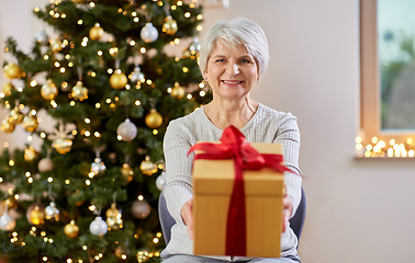 Image showing happy senior woman with christmas gift at home