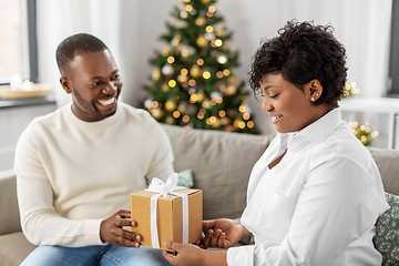 Image showing happy african couple with christmas gift at home