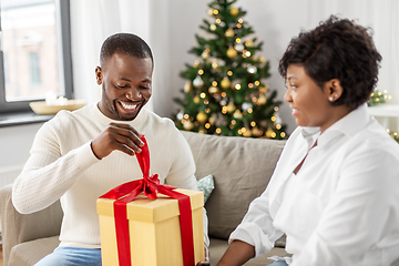 Image showing happy african couple with christmas gift at home