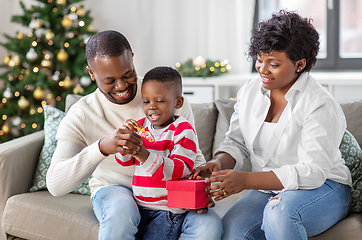 Image showing african family opening christmas gift at home