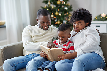 Image showing african family reading book on christmas at home