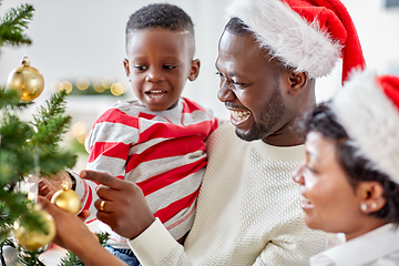 Image showing happy family decorating christmas tree at home