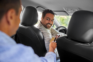 Image showing taxi car driver taking credit card from passenger