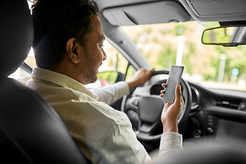 Image showing smiling indian man in car using smartphone