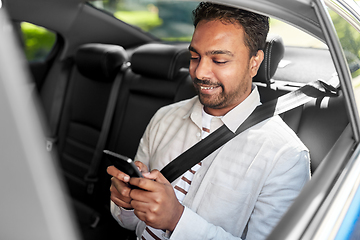 Image showing smiling indian man with smartphone in taxi car