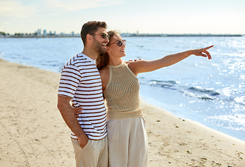 Image showing happy couple walking along summer beach