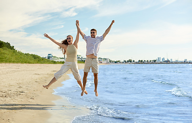 Image showing happy couple jumping on summer beach