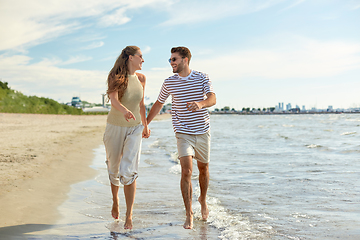 Image showing happy couple running along summer beach