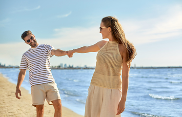 Image showing happy couple walking along summer beach