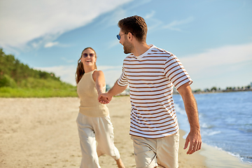 Image showing happy couple running along summer beach