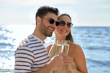 Image showing happy couple drinking champagne on summer beach