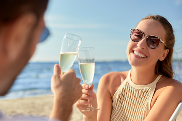 Image showing happy couple drinking champagne on summer beach