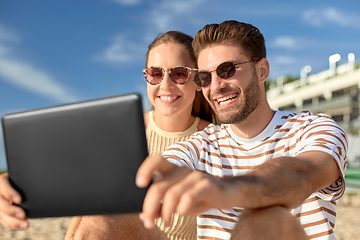 Image showing happy couple with tablet pc at on summer beach