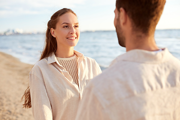 Image showing happy couple looking to each other on summer beach