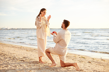 Image showing man with ring making proposal to woman on beach