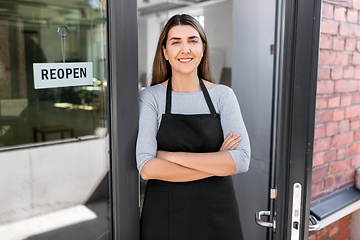 Image showing happy woman with reopen banner on door glass