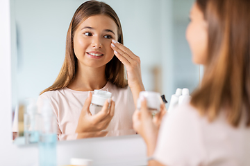 Image showing teenage girl with moisturizer at bathroom