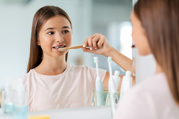 Image showing teenage girl with toothbrush brushing teeth