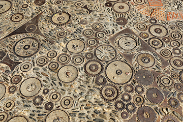 Image showing Unusual floor with pattern from pebbles, brick and rusty metal d