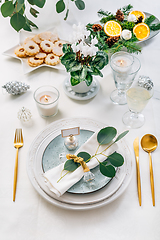 Image showing Christmas table setting with eucalyptus, cutlery and potted cyclamen in white and green tone