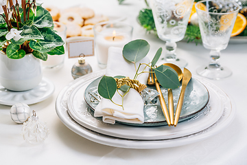 Image showing Christmas table setting with eucalyptus, cutlery and potted cyclamen in white and green tone